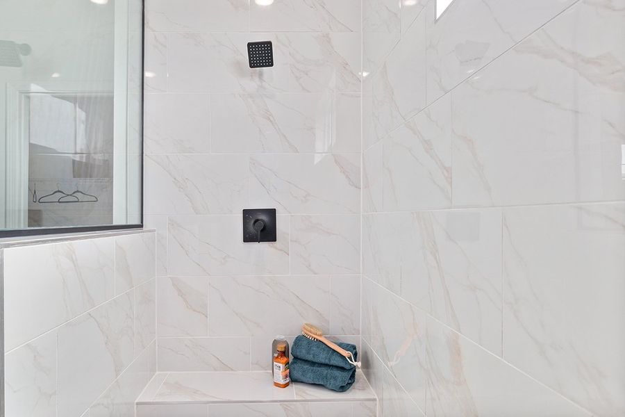 A bathroom with a tile wall.