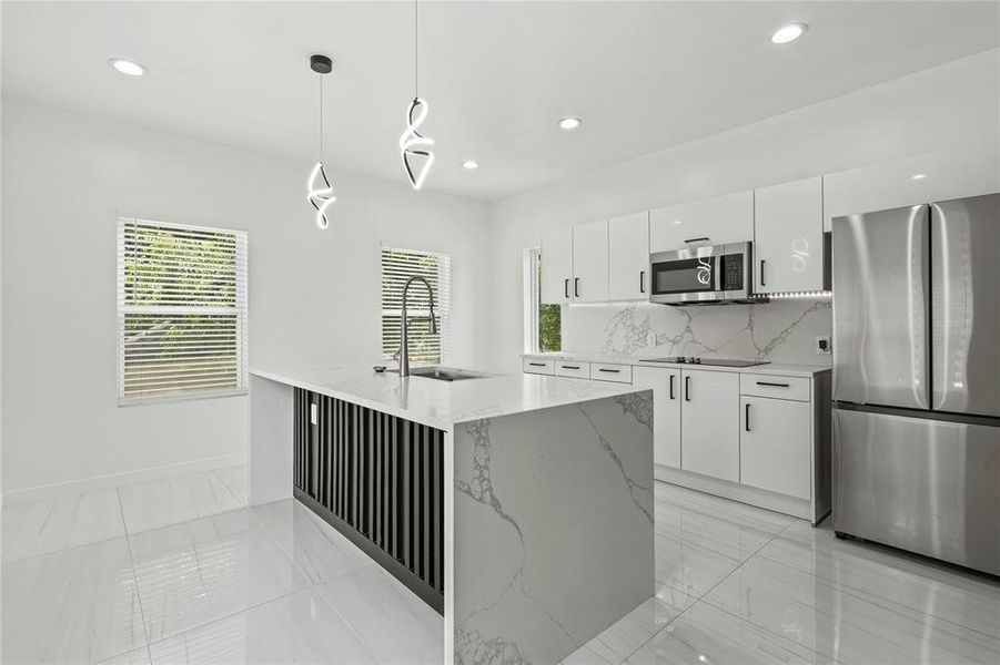 Kitchen with appliances with stainless steel finishes, white cabinetry, tasteful backsplash, recessed lighting, and modern cabinets Kitchen with appliances with stainless steel finishes, white cabinetry, tasteful backsplash, recessed lighting, and modern cabinets