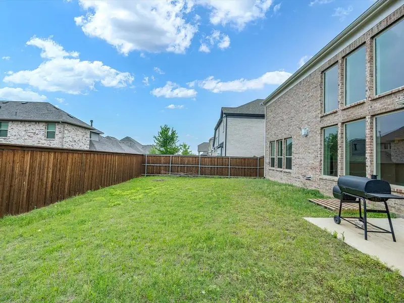 Expansive green lawn bounded by a privacy fence