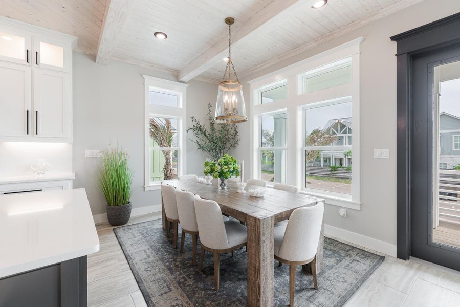Dining area with a wooden ceiling with exposed beams and baseboards Dining area with a wooden ceiling with exposed beams and baseboards