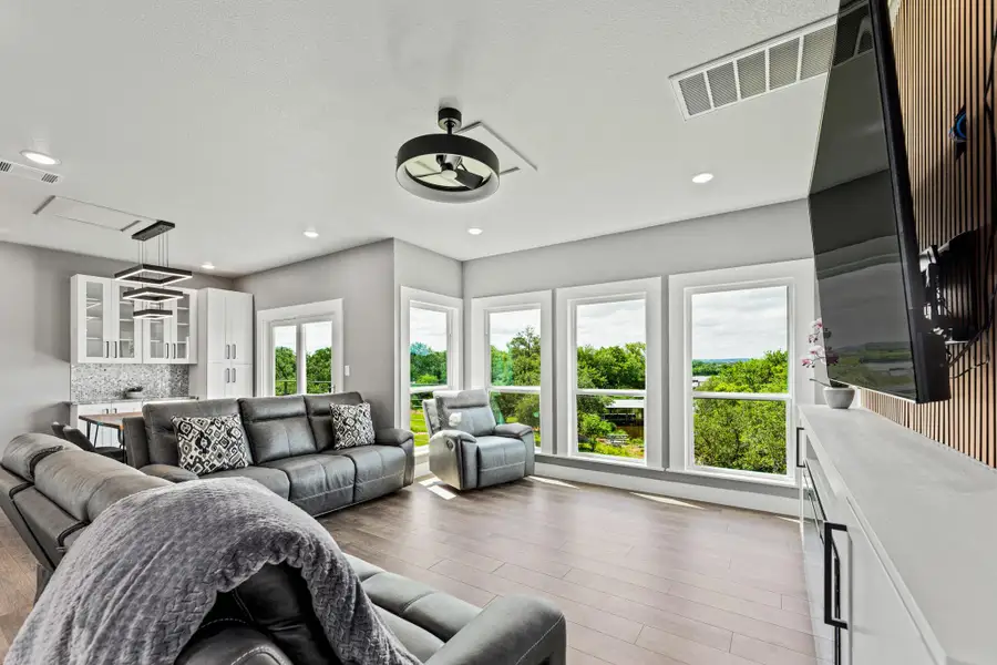 Open-concept living area featuring wood-finish flooring and ample natural light