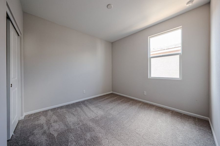A room with a carpet and a window.