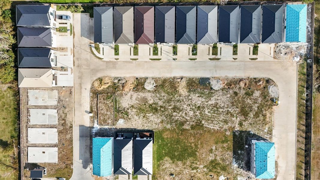 This bird's-eye view highlights the uniform modern architecture and the organized layout of the surrounding residential development.
