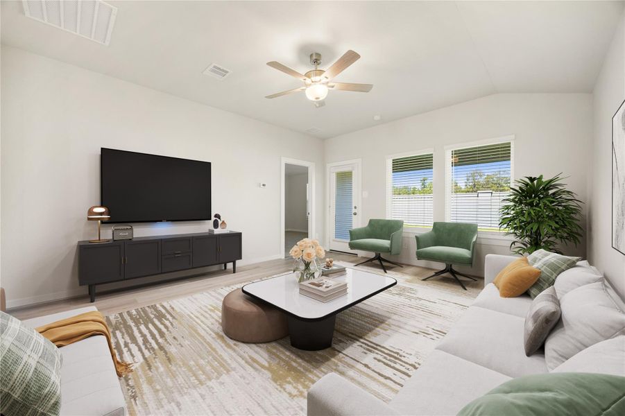 This spacious living area features large windows that fill the room with natural light and offer views of the backyard. Neutral finishes, recessed lighting, and luxury vinyl plank flooring create a bright and modern atmosphere perfect for everyday living.