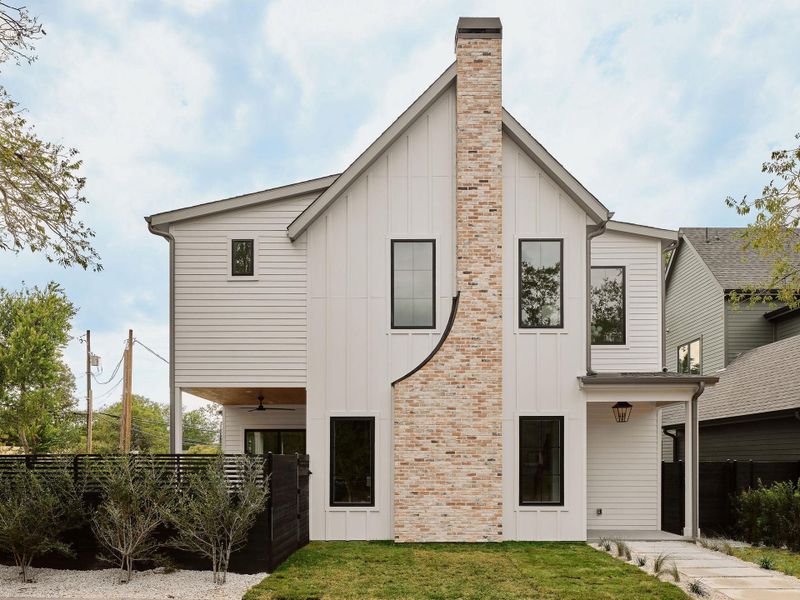 Rear view of house featuring board and batten siding, a ceiling fan, and a chimney Rear view of house featuring board and batten siding, a ceiling fan, and a chimney