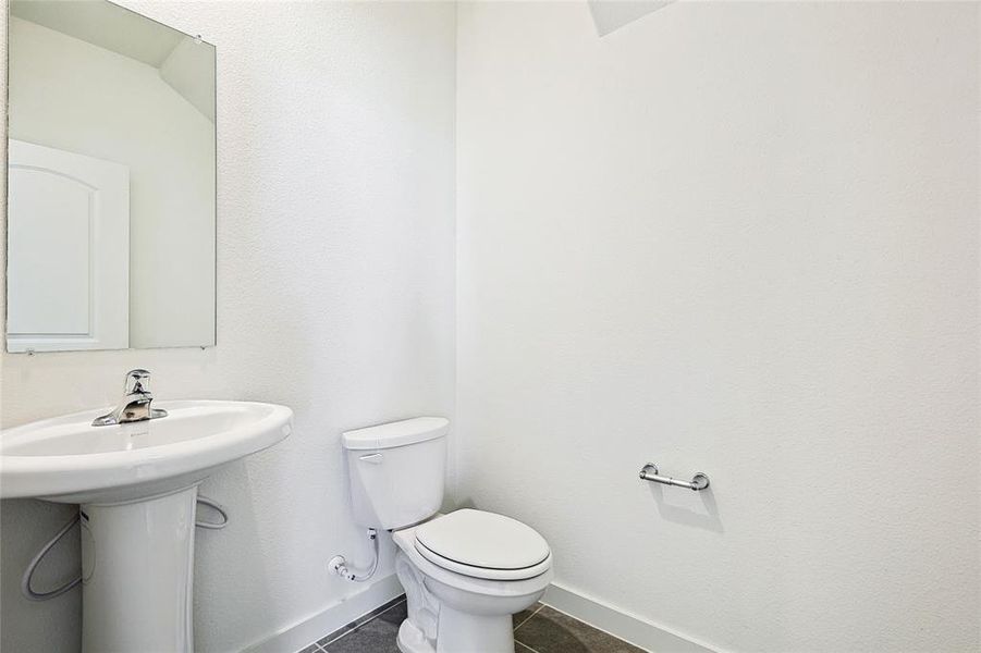 Bathroom featuring baseboards and dark tile patterned flooring