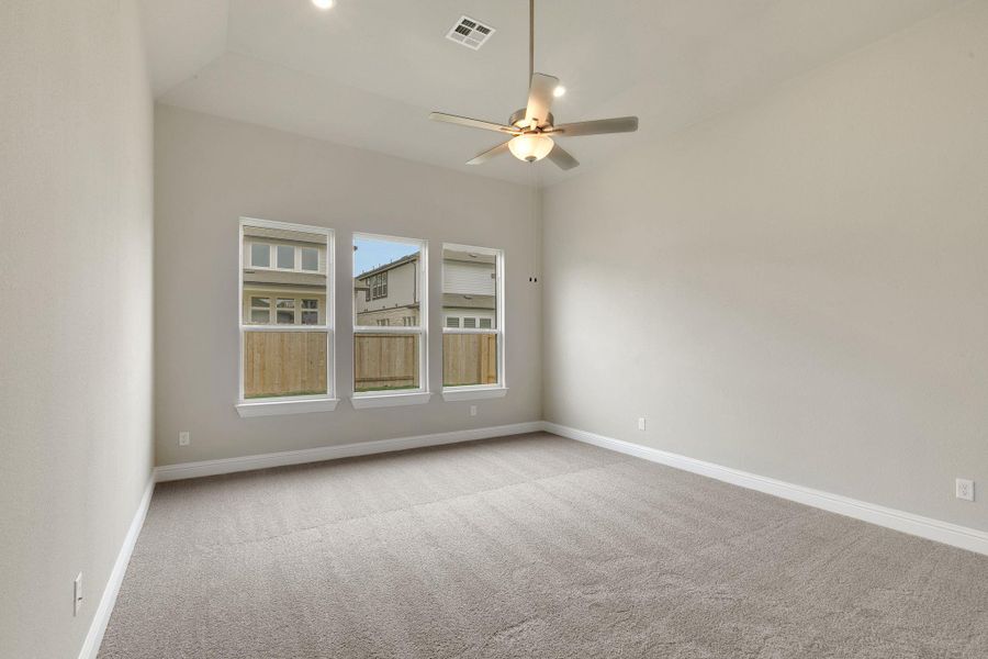 Carpeted empty room with ceiling fan, baseboards, and visible vents Carpeted empty room with ceiling fan, baseboards, and visible vents