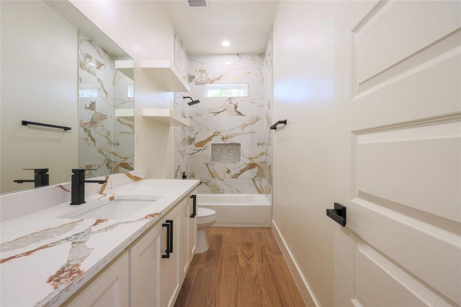 Secondary bathroom with an oversized vanity and marble look tile. Secondary bathroom with an oversized vanity and marble look tile.