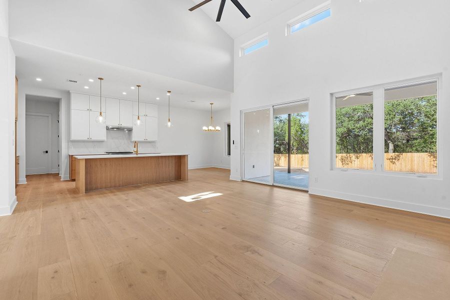 Gleaming hardwood floors run through this airy space with towering ceilings and glass doors.