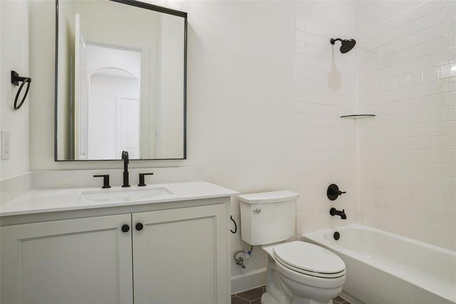 Full bathroom with toilet, vanity, and tiled shower / bath combo