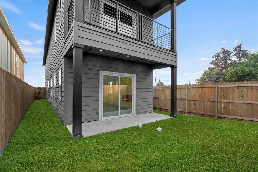 Back of house with a lawn, a patio area, and a balcony