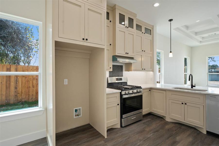 Kitchen featuring stainless steel appliances, backsplash, glass insert cabinets, dark wood-style floors, and recessed lighting Kitchen featuring stainless steel appliances, backsplash, glass insert cabinets, dark wood-style floors, and recessed lighting