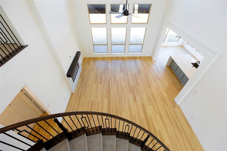 Stairs with a high ceiling, hardwood / wood-style flooring, and ceiling fan