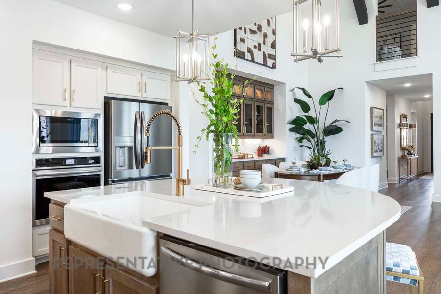 Kitchen featuring a chandelier, appliances with stainless steel finishes, a kitchen island, dark wood-style flooring, and light countertops Kitchen featuring a chandelier, appliances with stainless steel finishes, a kitchen island, dark wood-style flooring, and light countertops
