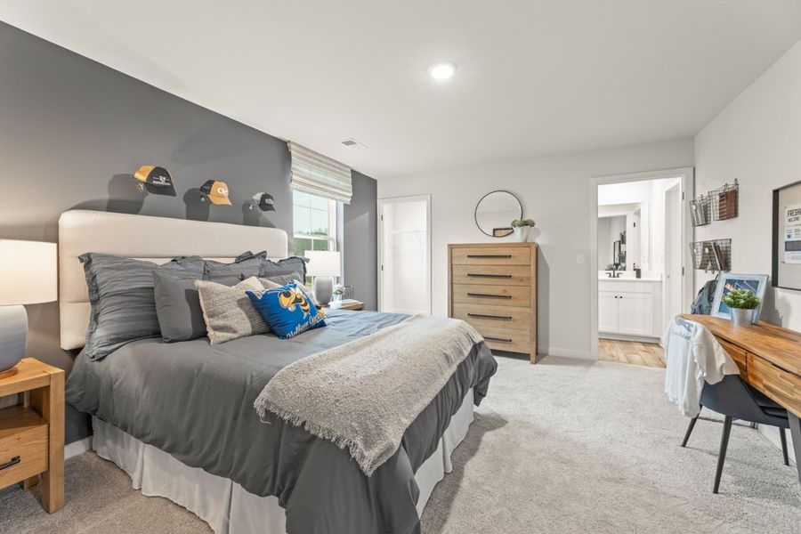 A bedroom with a bed and a desk.