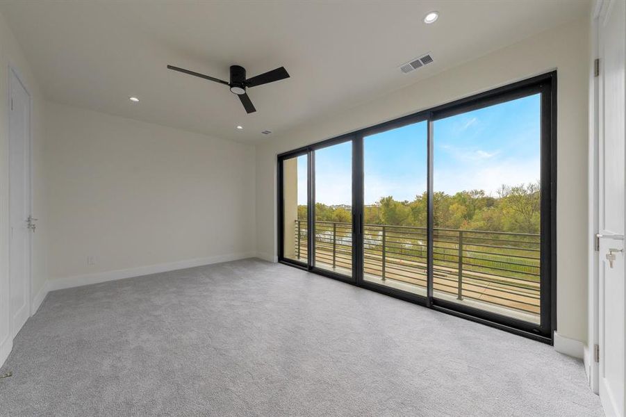 Bedroom 3, with light colored carpet, recessed lighting, a ceiling fan, a water view, and view of wooded area
