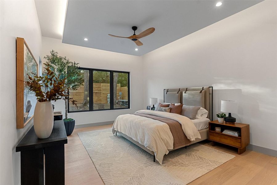 Tray ceiling in primary bedroom adds depth and accent lighting.