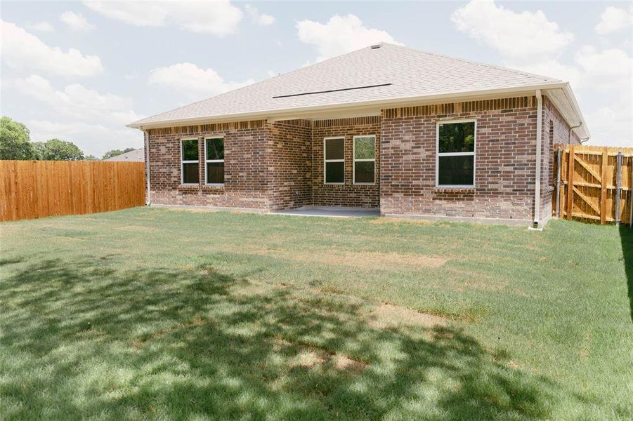 Back of house with a yard and a patio area