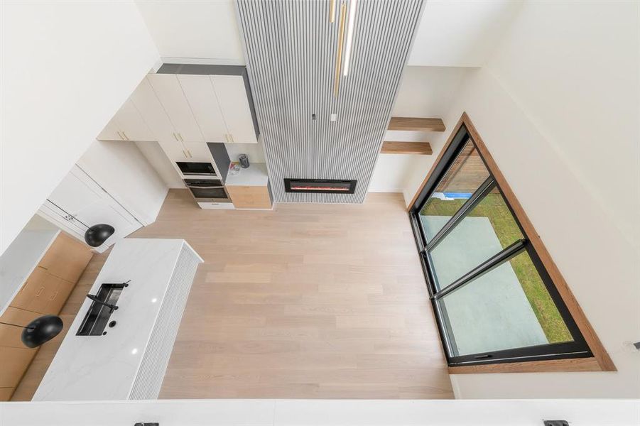 Living room featuring a glass covered fireplace and light wood finished floors Living room featuring a glass covered fireplace and light wood finished floors