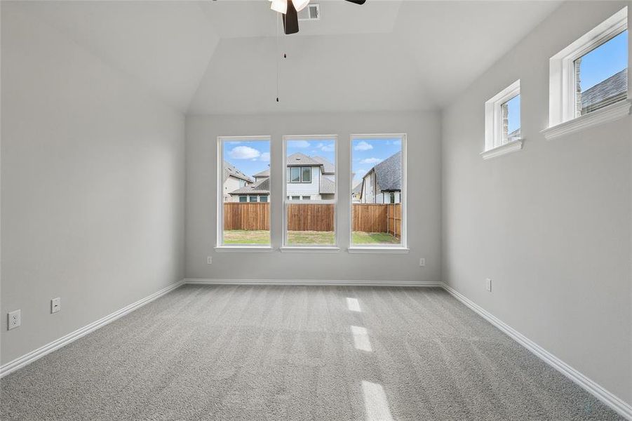 Unfurnished room featuring light carpet, a ceiling fan, and vaulted ceiling