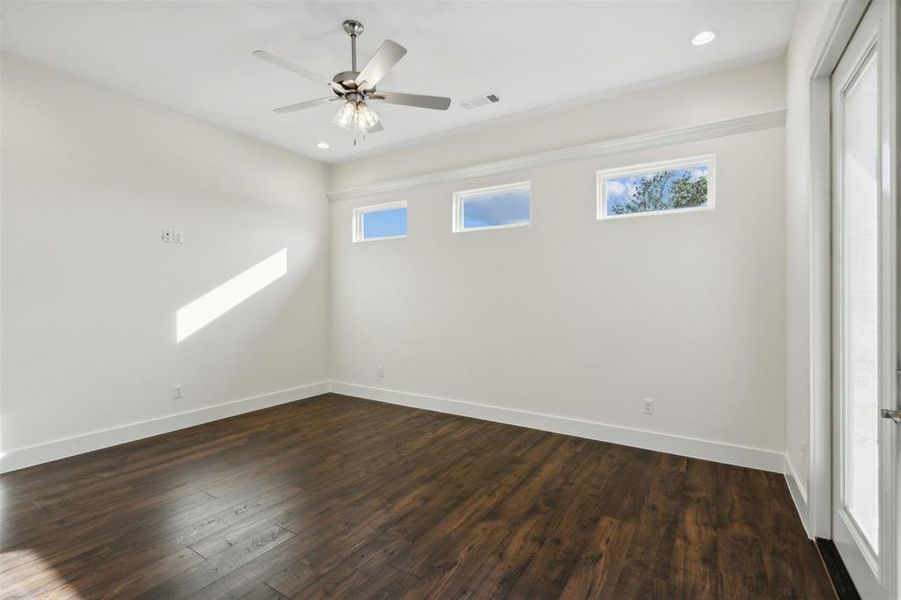 Empty room with ceiling fan and dark hardwood / wood-style floors