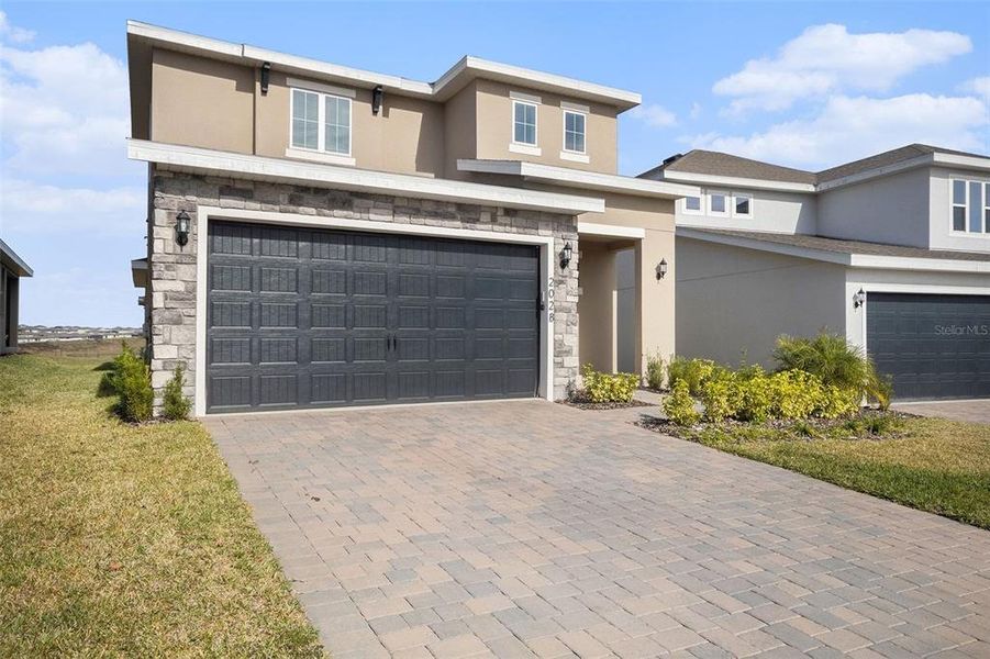 Front exterior of a new home in Hills of Minneola, Minneola, FL, highlighting curb appeal (Image 20).