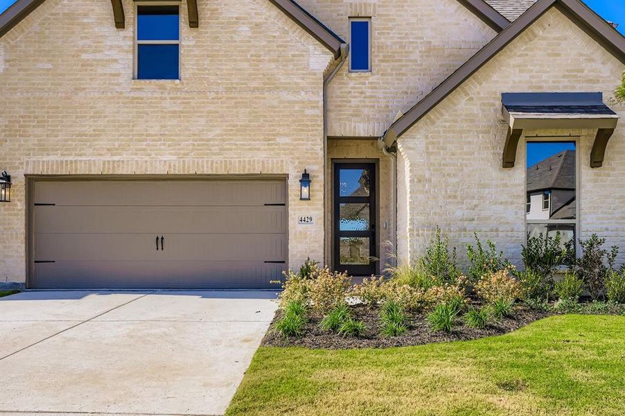 View of front facade with brick siding, an attached garage, and concrete driveway