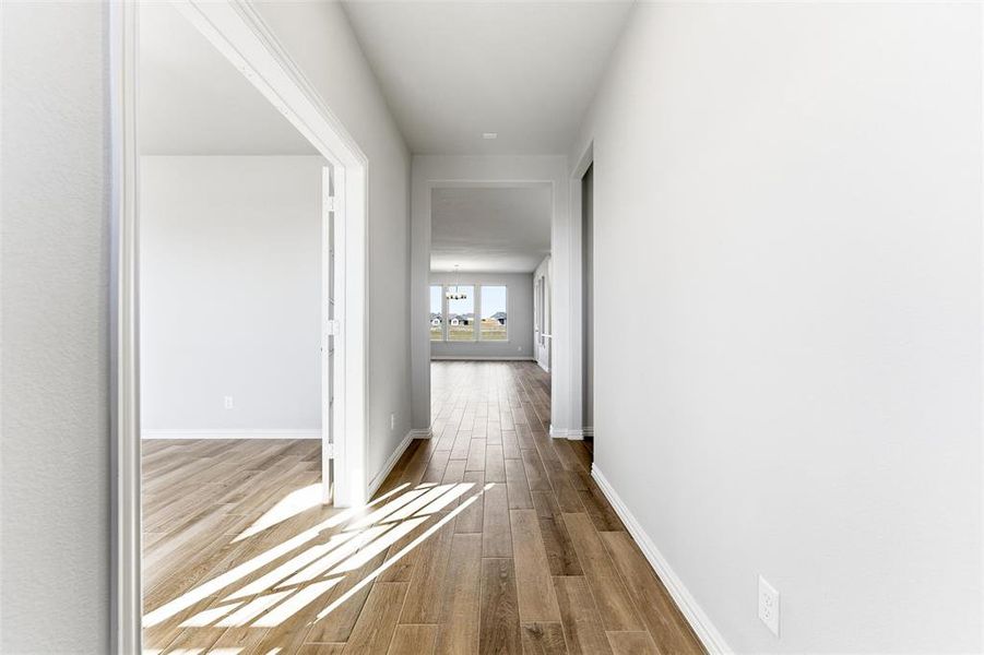 Corridor with dark wood-type flooring and baseboards