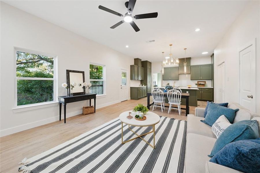 Living area featuring light wood-style flooring, recessed lighting, a chandelier, and ceiling fan