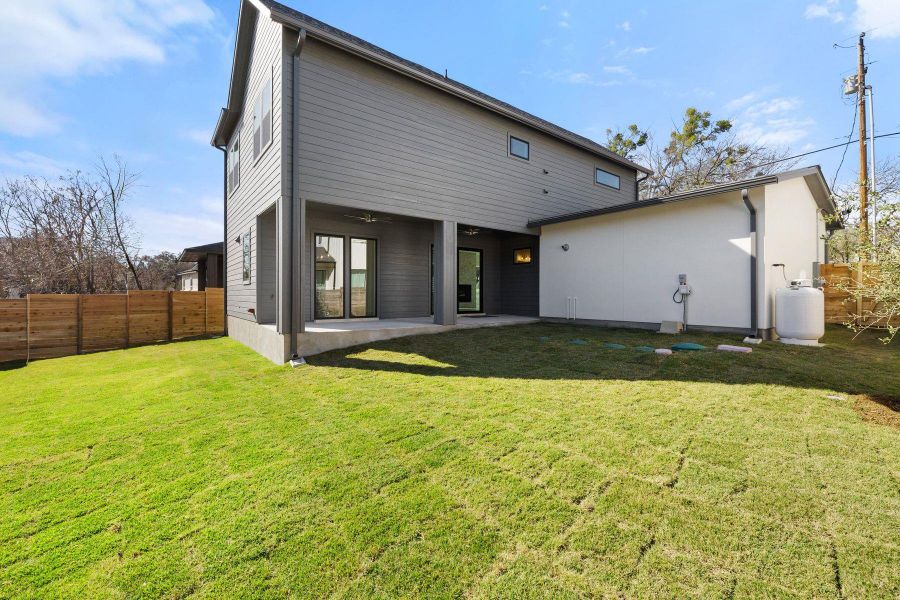 Rear view of property featuring a yard, a patio area, fence, and ceiling fan