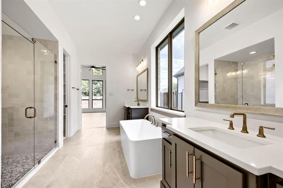 Modern bathroom featuring a freestanding tub, dual vanities with white countertops, and a spacious walk-in shower with glass enclosure Modern bathroom featuring a freestanding tub, dual vanities with white countertops, and a spacious walk-in shower with glass enclosure