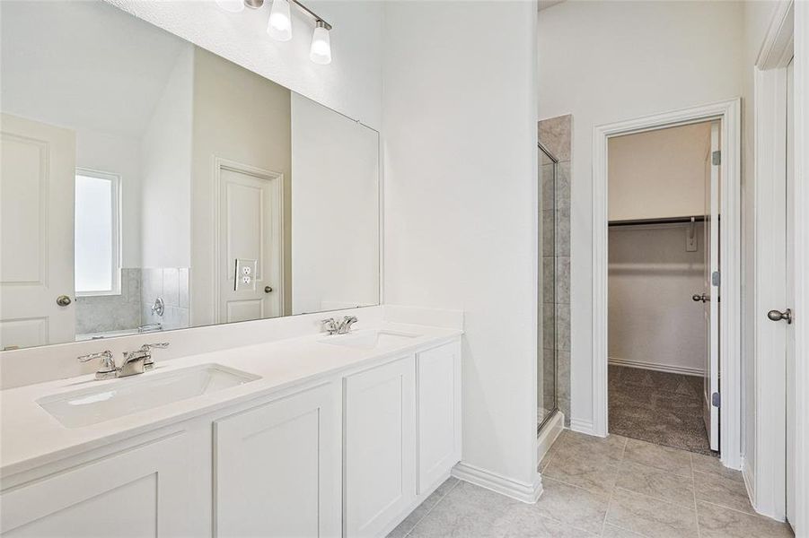 Bathroom featuring vanity, tile patterned floors, and walk in shower