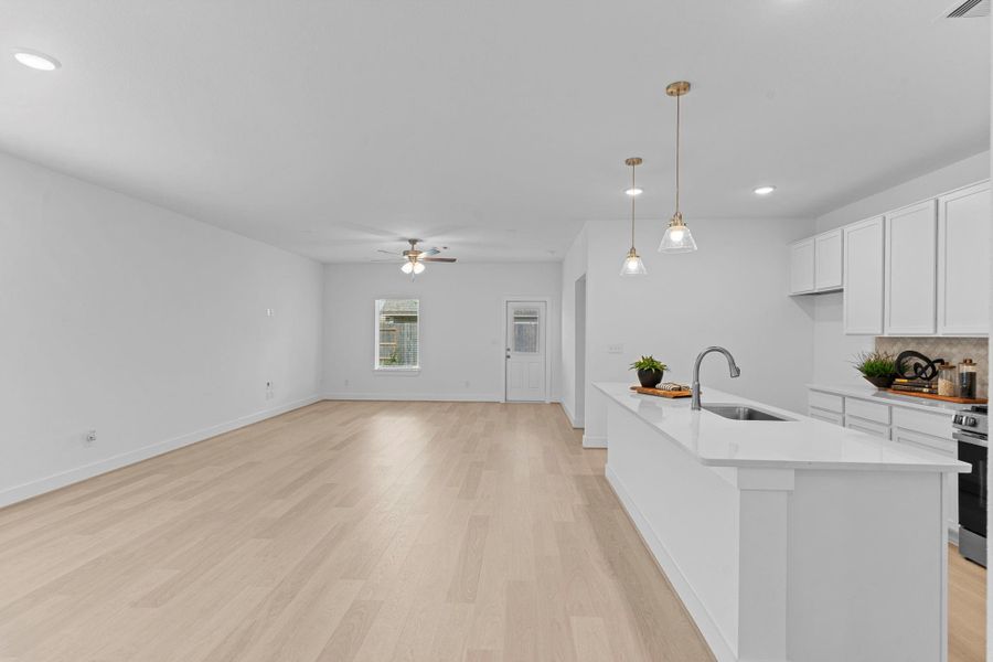 Step into the heart of the home — the open-concept kitchen and dining area! This bright space features gorgeous quartz countertops, white shaker-style cabinetry, modern lighting, and a large island perfect for meal prep or casual dining with family. **Image Representative of Plan Only and May Vary as Built**.