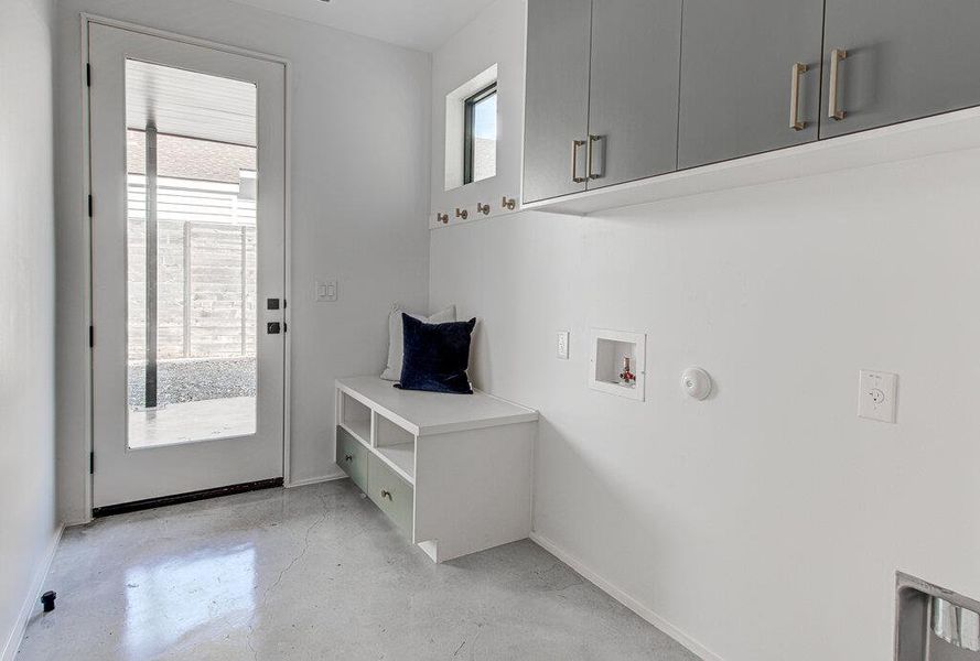 Clothes washing area with cabinet space, plenty of natural light, washer hookup, and baseboards