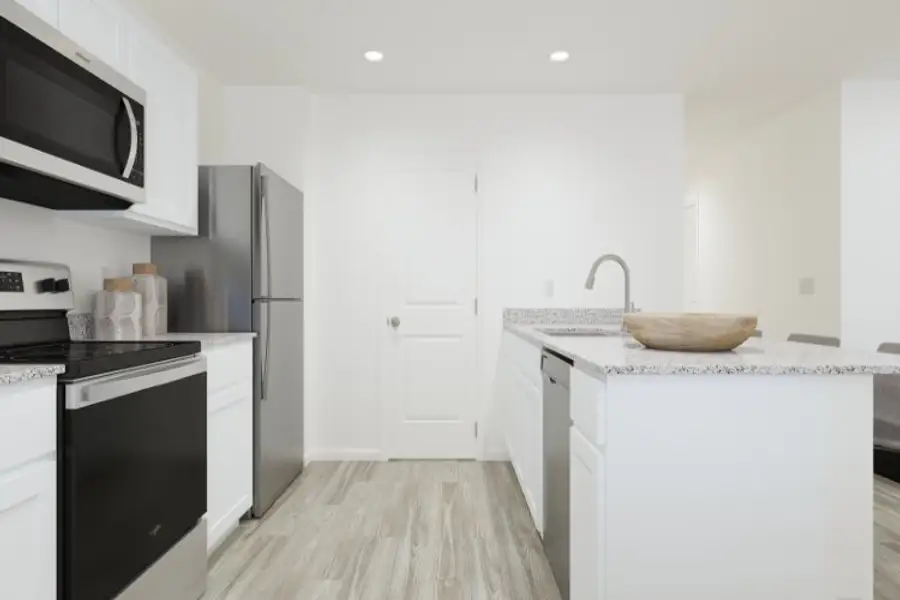 A kitchen with white cabinets.
