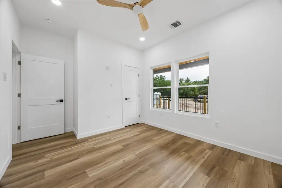A well-lit room featuring warm wood flooring and ample natural light from large windows. A well-lit room featuring warm wood flooring and ample natural light from large windows.
