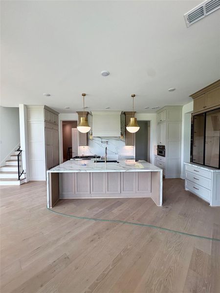 Chef's kitchen with large island and built-in fridge. Photo as of 5.18.26