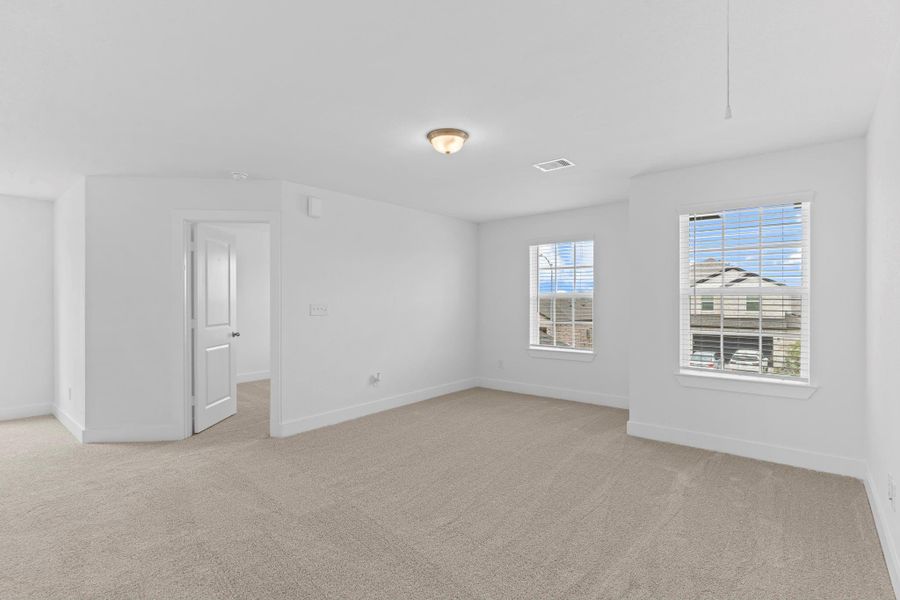 A different angle of the spacious upstairs game room highlights its flexibility, with plenty of room for a media setup, play area, or additional seating—all enhanced by plush carpeting and natural light. **Image Representative of Plan Only and May Vary as Built**.