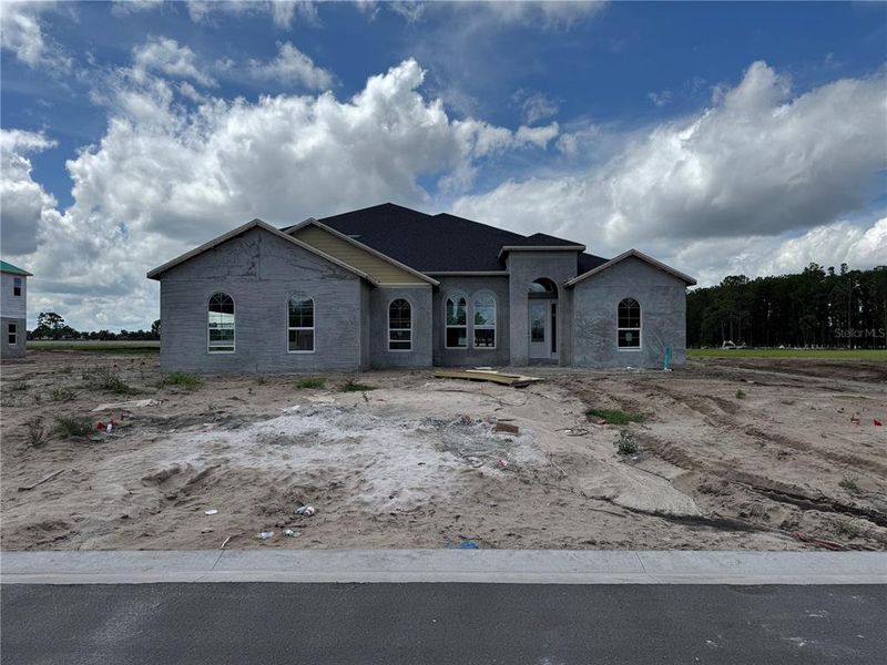 Front exterior of a new home in Solace at Corner Lake, Orlando, FL, highlighting curb appeal (Image 1).