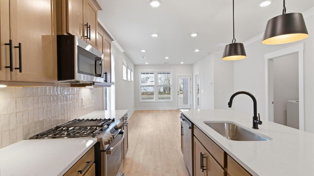 Elegant kitchen with large island and pendant lighting in this first-class DRB Homes design