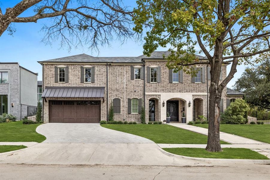 View of front of property with a garage and a front lawn