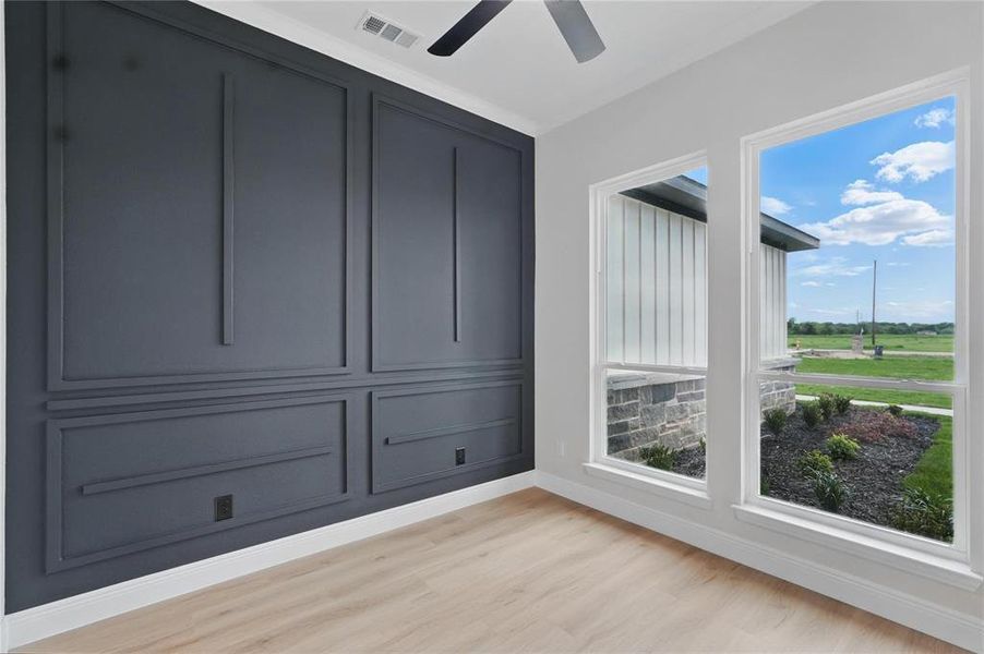 Spare room featuring light wood finished floors and a ceiling fan Spare room featuring light wood finished floors and a ceiling fan