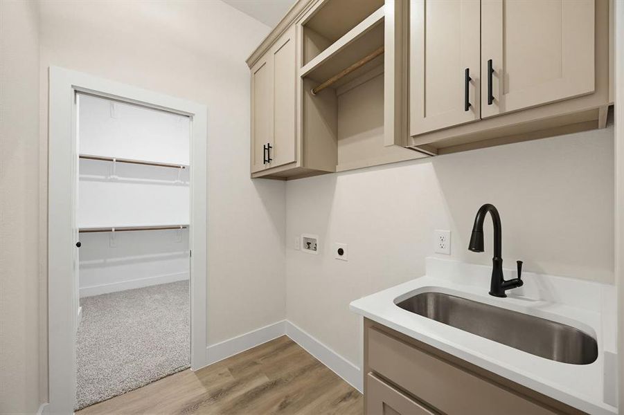 Laundry area featuring wood-finish flooring and light-toned walls