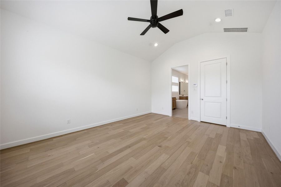 Primary suite featuring soaring ceilings, abundant natural light and wood flooring throughout