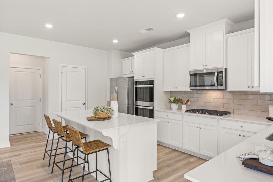A kitchen with white cabinets.