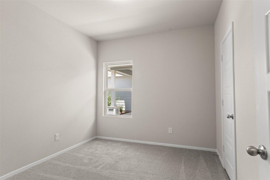 Carpeted spare room featuring baseboards