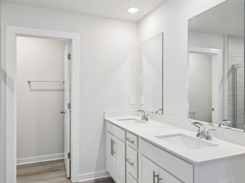 The primary bathroom offers dual vanity sinks and a walk-in shower.