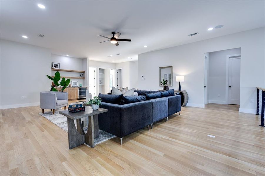 Living room with ceiling fan and light wood-type flooring