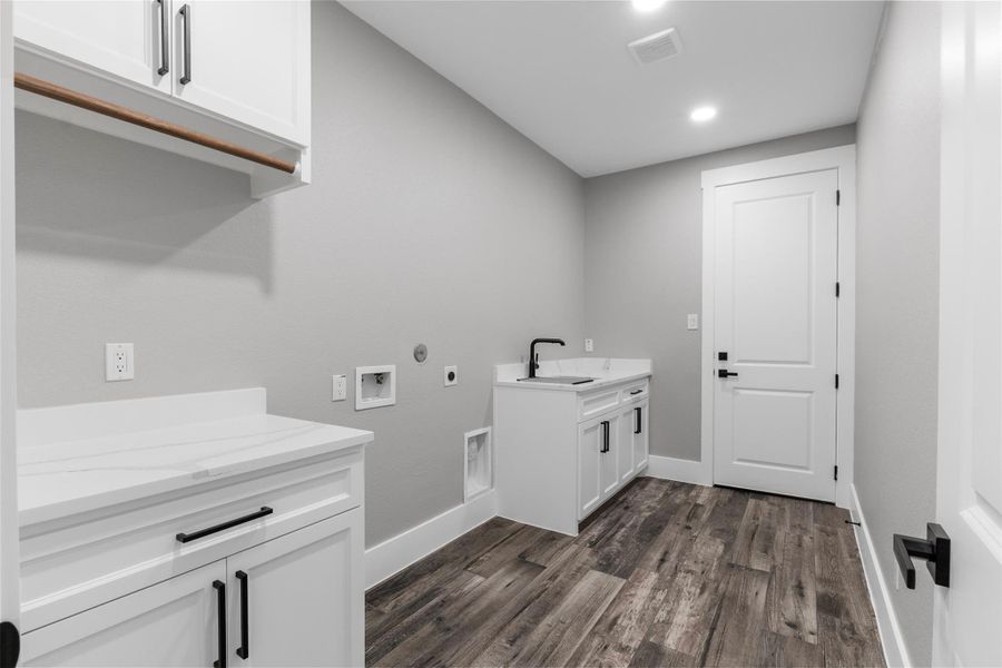 Laundry room with cabinetry and ample countertop space.