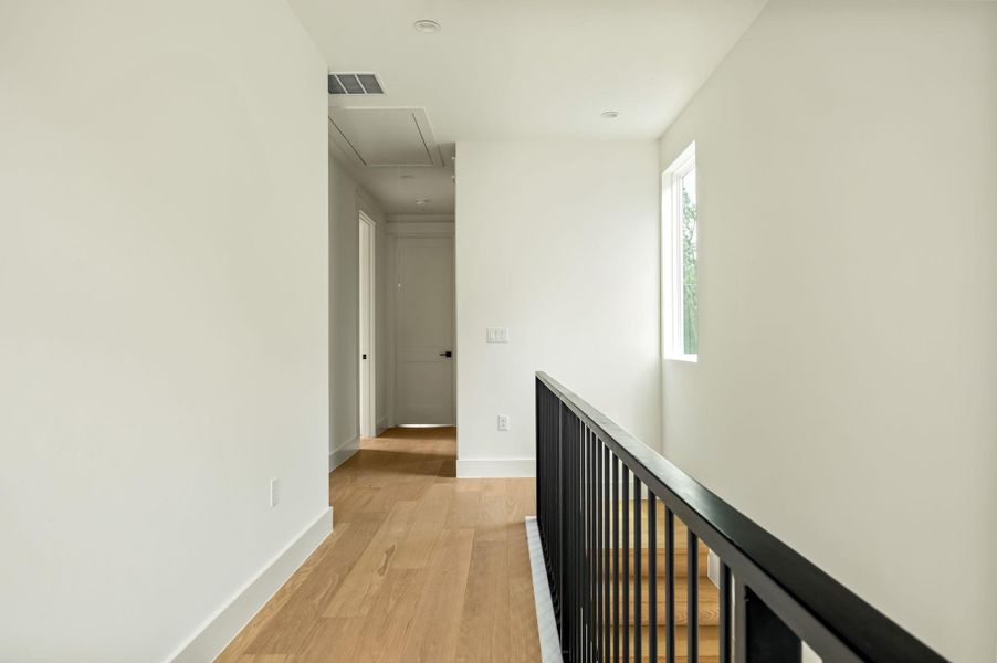 Clean lines and light wood flooring define this bright upstairs hallway.